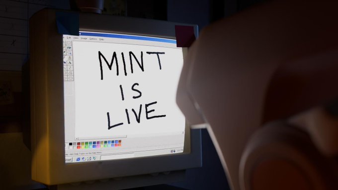 A computer monitor displays the handwritten message "MINT IS LIVE" in a digital painting program, signaling the launch of the Blokyz Original NFT mint event.