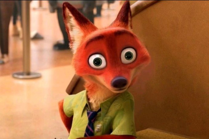 A still from the animated movie Zootopia showing the character Nick Wilde, a red fox wearing a green shirt and tie, looking surprised.