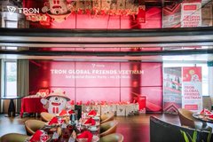 The image shows an event venue with a large stage screen displaying "TRON GLOBAL FRIENDS VIETNAM – 3rd Special Dinner Party," along with TRON and Saturn Chain logos visible on the backdrop. The room is decorated for a festive gathering with floral arrangements and illuminated signage, perfectly capturing the celebratory atmosphere of this KOL appreciation dinner hosted by TronDao VIE in Ho Chi Minh City.