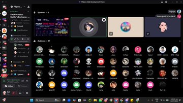 A Discord interface screenshot showing voice channels 'Spottswood 1' and 'Auditorium 1' with user avatars in voice chat and a list of server members on the left sidebar.