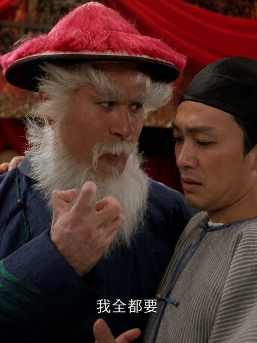 A scene from a Chinese period film showing an older man with a long white beard and red hat gesturing toward a younger man in dark clothing, with the Chinese subtitle "我全都要" (I want it all).