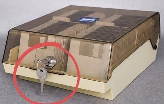 A vintage beige box with a transparent brown lid features a front-mounted key lock, circled in red, showcasing an early method of hardware security.

This image directly illustrates the "Then" in the "Then vs Now Hardware locking it down" comparison, highlighting a physical key lock as a classic example of hardware-based security before modern digital authentication methods.