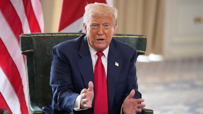 President Trump speaks while seated in front of American flags, relating to his upcoming meeting with crypto industry leaders to discuss the CLARITY Act and crypto regulation.