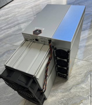 A photo of a cryptocurrency mining rig featuring a Bitmain Antminer with a blue stripe and visible cooling fans on a tiled floor.
