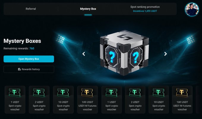 A "Mystery Box" promotional interface showing a 3D cube with question marks and various reward tiers ranging from 1 USDT to 100 USDT in spot crypto and futures vouchers.