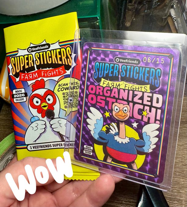 A hand holding two VeeFriends 'Super Stickers Farm Fights' cards, with the orange 'Coward' card on the left and the purple 'Organized Ostrich' card (06/15) on the right, featuring a 'Wow' text overlay.