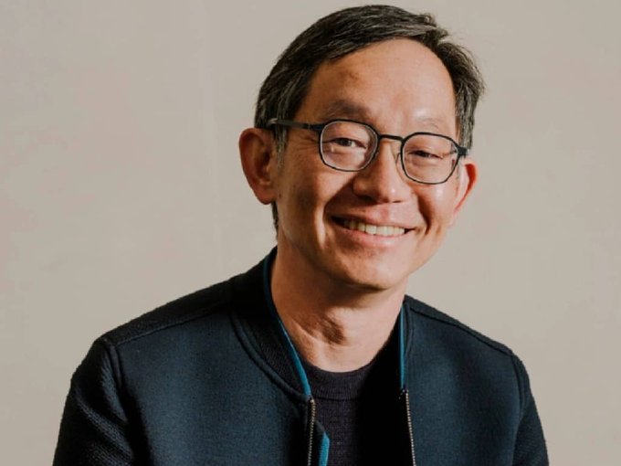 A smiling man with glasses, Evan Cheng, co-founder and CEO of Mysten Labs, the company behind the Sui blockchain. The image connects to the post by highlighting Cheng's vision for Sui as foundational internet infrastructure, contrasting with the market's current altcoin-like valuation of the token.