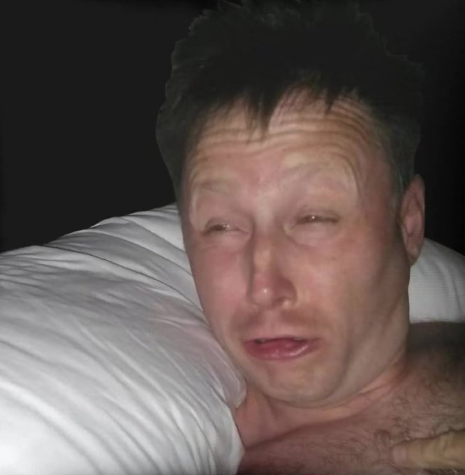 A close-up selfie of a man on a white pillow with flushed, reddened skin, appearing to be in a vulnerable or emotional state.