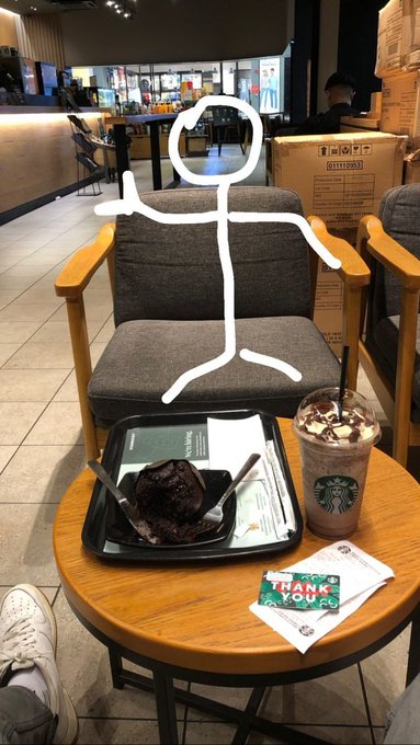 A cozy Starbucks setup with a chocolate brownie dessert, iced Frappuccino, and a "Thank You" gift card displayed on a small wooden table beside gray cushioned chairs. The post caption "good evening, legends! happy thursday.." pairs well with the relaxed evening treat and appreciation vibe suggested by the thank you card.