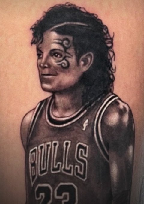 A detailed tattoo on someone's skin depicts Michael Jordan in his Chicago Bulls #23 jersey, complete with his signature face paint, capturing three references to "Mike" (Michael Jordan, microphone for the post's audio pun, and the nickname itself) in one image.
