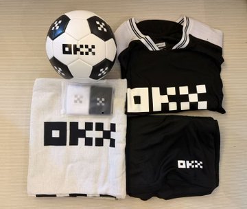 The image features a soccer ball with black and white squares, along with two sets of sports clothing items - one set consisting of a shirt and shorts, while the other includes a pair of shorts and a t-shirt. The clothing items are neatly arranged on top of a table or countertop.