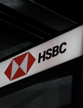 The HSBC bank logo and wordmark are illuminated on a dark sign panel against a black background.