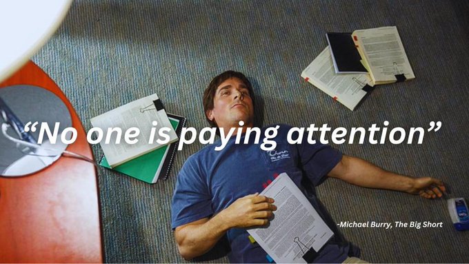 iced coffee on a red table, with a stack of books and a phone nearby, accompanied by the text "No one is paying attention".