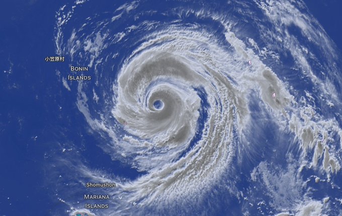 A satellite image of a massive hurricane or typhoon with a clear eye, labeled with locations including Bonin Islands, Shomushon, and Mariana Islands.