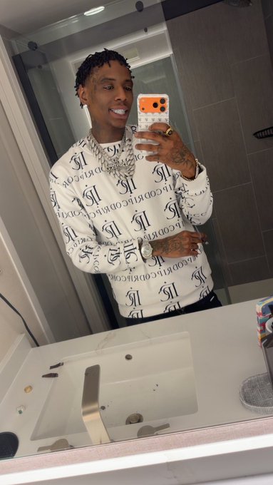 A young man with braided hair smiles in a bathroom mirror selfie, wearing a white long-sleeve shirt with repeating "RECORDING IS" text, layered with multiple diamond chains and rings while holding an orange-cased phone. The accompanying dexscreener.com/solana/c4ghgcz link suggests the image is being used to promote a Solana-based token, with the "Recording" branding hinting at the token's name or theme.