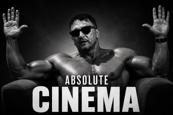 The image features a muscular man with sunglasses sitting in a chair, holding his arms up as if he's about to give a speech or make an announcement. The background of the image is black and white, which adds to the dramatic effect. The caption below the image reads "Absolute Cinema", indicating that this photo was taken for a promotional post related to a movie called "Absolute Cinema".