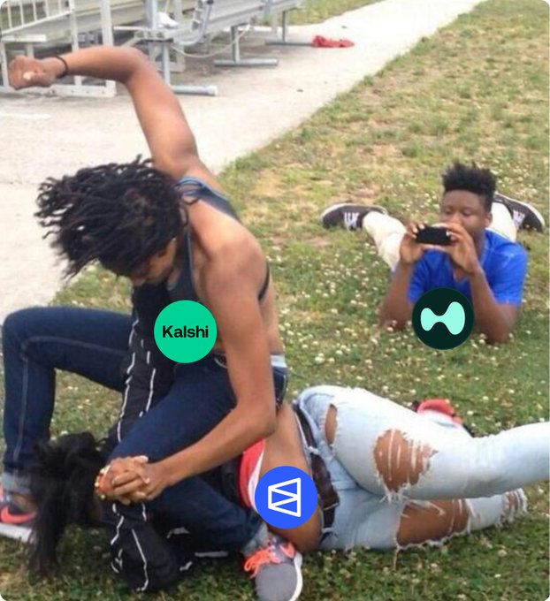The image shows three people sitting on the grass, with one person wearing a black tank top and another person wearing a blue shirt. The third person is holding a cell phone. A caption below the photo reads "Kalshi is launching perpetual futures a counter strike against @Polymarket what's your next move blue warrior?".