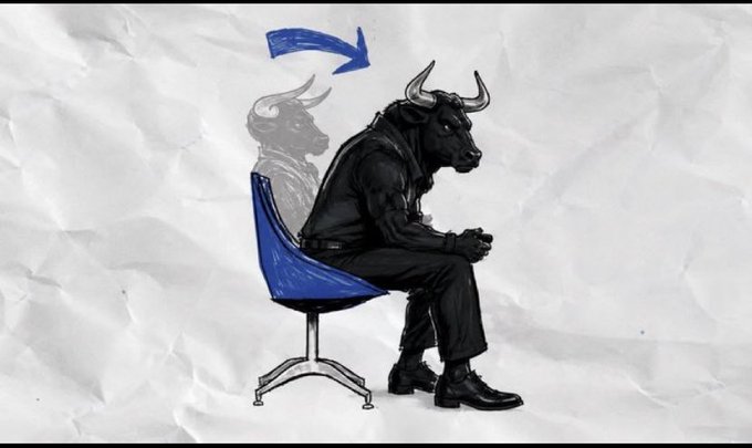 A surreal image of a humanoid figure with a bull's head wearing a black suit, sitting on a blue chair on a crumpled paper background, with a faded duplicate figure behind it and a blue curved arrow above.