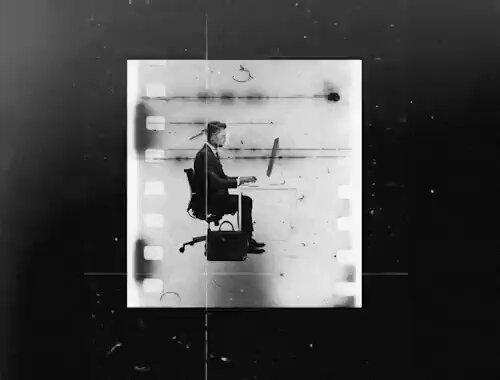 This black and white photograph shows a man sitting at an office desk, typing on a computer. In addition to the main subject of the photo, there are two extra dots located near the bottom edge of the frame that appear to be floating air bubbles or shadows in the background. The image also contains some text below it that reads "✧ 5 More Minutes ✧ by hittman for 0.3621 ETH ($612.17) $RARE". This additional information suggests that this photo might have been taken as part of a series, an art project, or even as part of a marketing campaign related to the product offered on @graffitiongrave's website.