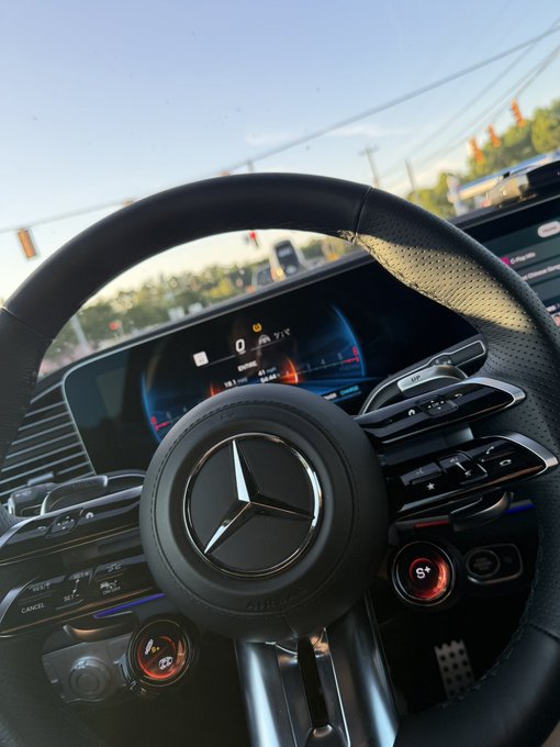 Interior view of a Mercedes-Benz vehicle, prominently featuring the steering wheel with the iconic Mercedes logo, digital dashboard display showing speed, and performance controls including a red "S+" button. The image ties to the post's "Riding with" theme, suggesting cruising in a luxury car while expressing bullish sentiment on $KNIGHT as a rising crypto token.