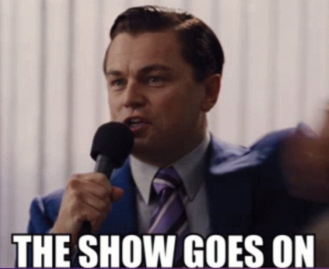 A meme featuring Leonardo DiCaprio as Jordan Belfort from 'The Wolf of Wall Street' speaking into a microphone with the caption 'THE SHOW GOES ON.'