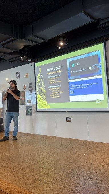 The image shows a man standing behind a podium, giving a presentation or speech at an event. The man appears to be wearing a black shirt and blue jeans. On the screen behind him, there are two presentations displayed - one with a green background and white text, and another with a yellow background and white text. The post also mentions that it is related to Bitcoin Cash and Bitcoin.