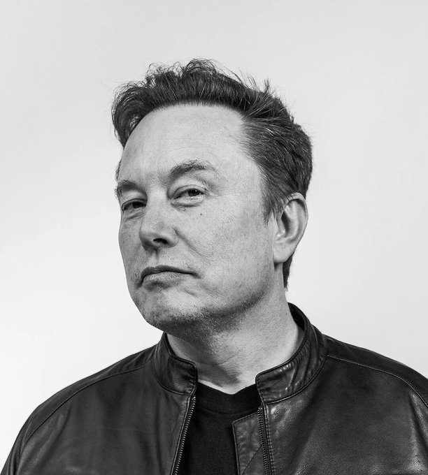 A black-and-white portrait of Elon Musk in a leather jacket, staring off into the distance with a contemplative, serious expression, visually reinforcing his ominous quote about future predictions from his interview.