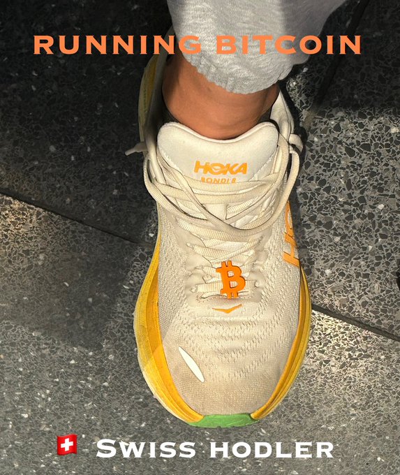 Photo of a cream and orange Hoka Bondi running shoe with a Bitcoin 'B' logo on the laces, captioned 'RUNNING BITCOIN' and 'SWISS HODLER'.