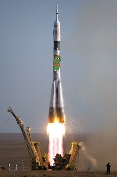 A rocket launches from a desert landscape, with visible rocket stages and exhaust flames at the base.