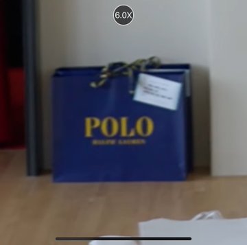 A row of blue Polo Ralph Lauren shopping bags sitting on the floor next to a bed.