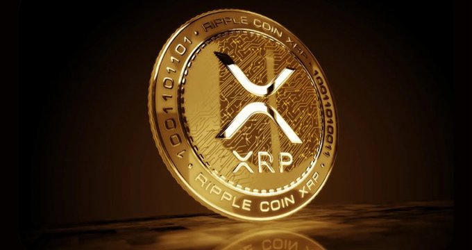 A gleaming gold Ripple Coin XRP token stands on a reflective surface, displaying its "XRP" logo and "RIPPLE COIN XRP" text alongside binary code along its rim. The image visually reinforces the post's message about growing institutional interest in XRP, as the physical coin representation underscores the cryptocurrency's legitimacy and the increasing appeal of XRP-based financial products like ETFs.