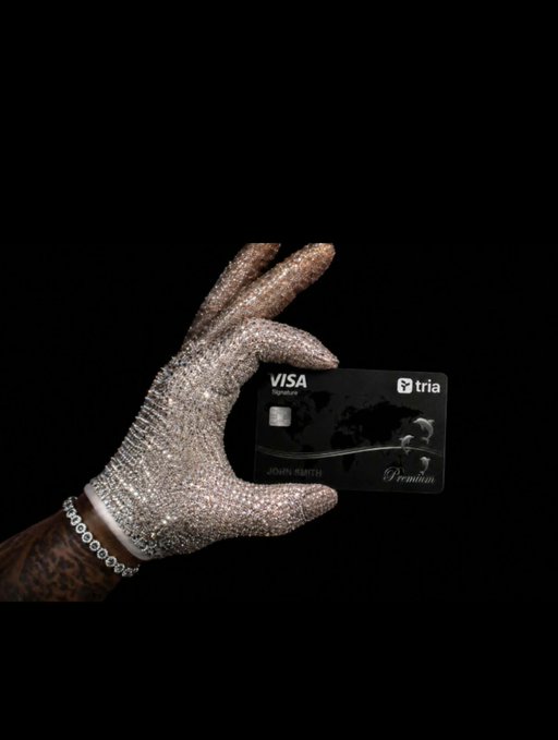 The image features a hand holding a black Visa credit card with a silver stripe down its center against a black background. The text "@useTria" appears near the bottom of the image, which could be related to the credit card company or an online payment platform. The focus on simplicity and ease of use is emphasized by the hand holding up the credit card without any additional context or explanation.