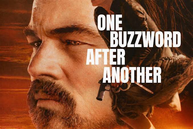 The image is a promotional poster-style graphic featuring a close-up of a bald man with a goatee on the left side, a hand holding a gun on the right, and the bold white text "ONE BUZZWORLD AFTER ANOTHER" overlaid against a fiery orange background.

The caption cleverly riffs on the "One Buzzword After Another" text, humorously suggesting that Bitcoin's recent move may be propped up by sustained call overwriting at low volatility rather than genuine market conviction—much like the gritty, high-stakes drama implied by the poster's intense imagery.