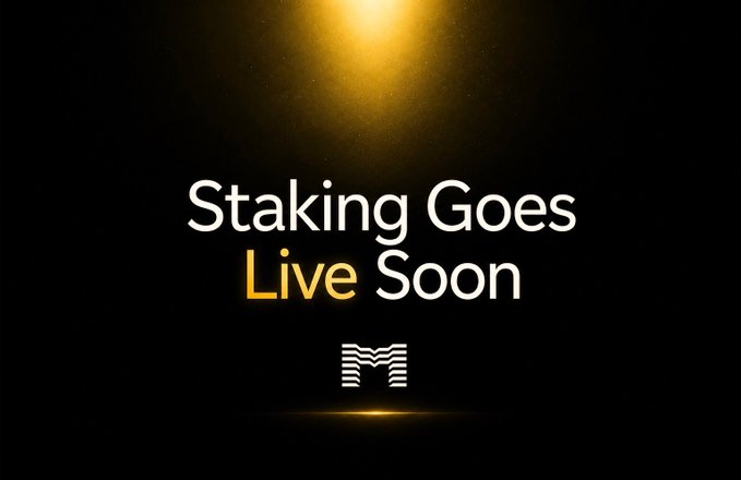 A dark promotional graphic with a glowing golden light reading 'Staking Goes Live Soon' with an 'M' logo below.