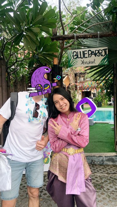 A couple poses in front of a "Blue Parrot" sign in Xcaret, with their faces covered by purple Pepe and Monad-style logos, nodding to the post's theme of choosing "Monad" after careful deliberation.