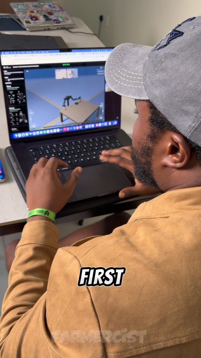 A man wearing a gray cap and tan jacket sits at a laptop, viewed from behind, working on what appears to be a 3D design with the text 'FIRST' overlaid.