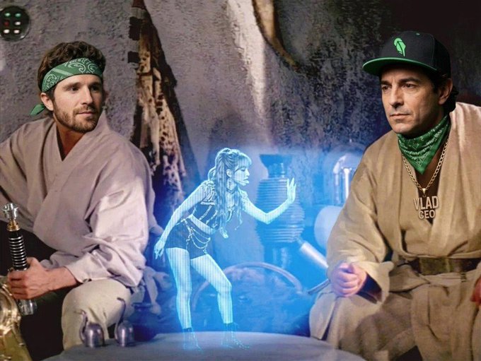 Two men in Star Wars-inspired desert garb watching a blue holographic projection of a dancing woman, resembling a Star Wars cantina scene with VladGeo branding.
