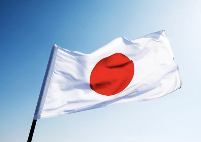 The Japanese flag waves against a clear blue sky, symbolizing Japan as the country where Progmat has completed the migration of over $3 billion in digital securities from the Corda platform to an Avalanche L1 network.