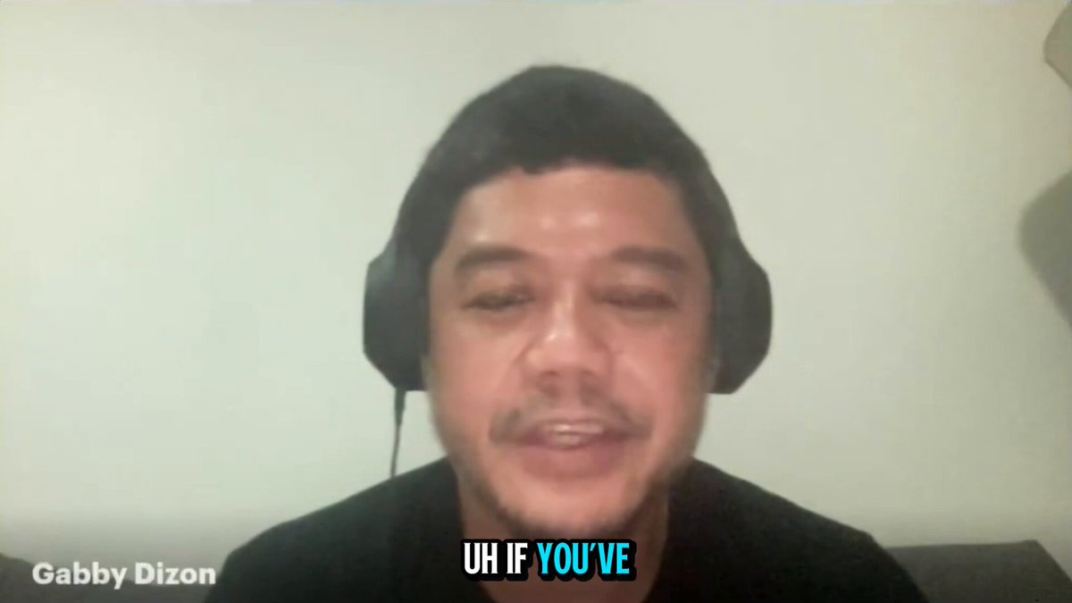 The image features a man wearing headphones, with his face partially visible behind them. The background appears to be a white wall or a gray surface. There are two lines of text in the image that read "uh if you've" and "@gubisch". These texts seem to be related to a conversation about video games, possibly discussing a game called @Vibecode_game.