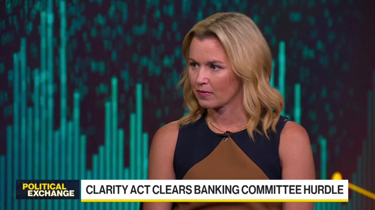 The image features a woman with blonde hair wearing a brown dress, standing against a blue background that has green lines. The text "POLITICAL EXCHANGE" appears at the top of the image, while "CLARITY ACT CLEARS BANKING COMMITTEE HURDLE" is written below her. The post also mentions that it was published on January 6th and that it will impact the 2026 elections.