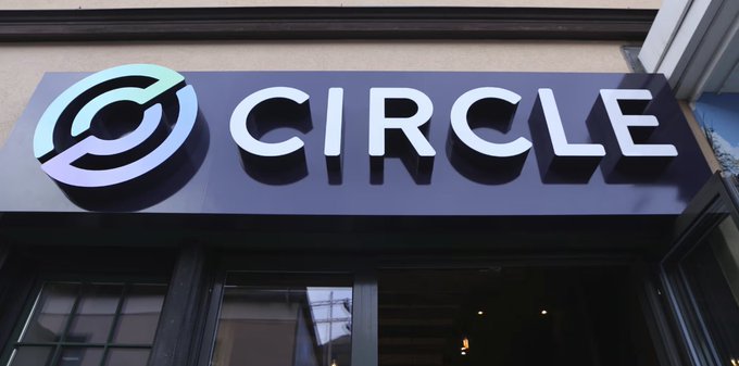 A storefront sign displays the "CIRCLE" logo and name, representing the stablecoin issuer Circle as it receives final OCC approval to establish a national trust bank in the US, signaling its evolution beyond a crypto market tool toward traditional financial infrastructure.