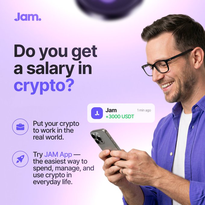 An advertisement for the 'Jam.' crypto app featuring a smiling man in a purple shirt looking at his phone, with text 'Do you get a salary in crypto?', 'Put your crypto to work in the real world.', 'Try JAM App — the easiest way to spend, manage, and use crypto in everyday life', and a notification showing '+3000 USDT'.