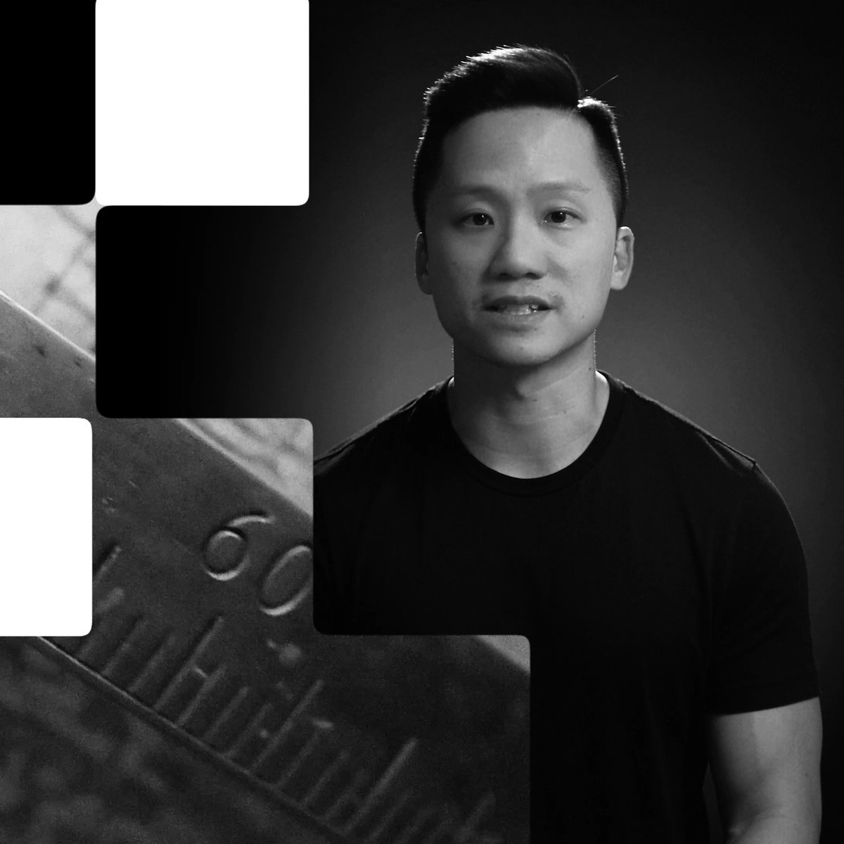 A black-and-white portrait of a young man in a dark t-shirt, set against a dark backdrop with a close-up of a coin embossed with "600" visible in the lower-left corner, suggesting a speaker or host tied to the OKX Now Singapore event.