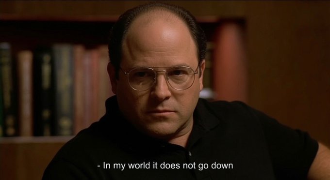 A man with glasses and a serious expression sits in front of a bookshelf, with the caption "- In my world it does not go down." His stern, unwavering look conveys absolute certainty, humorously mirroring the defiant confidence the meme suggests when dismissing the possibility of a financial downturn.