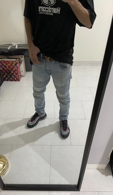 A mirror selfie captures a person wearing a black t-shirt with mirrored "HIGHCUT" text, paired with light wash skinny jeans, a designer belt, and multicolored Nike Air Max 97 sneakers, responding to the "Gn bros" post with an outfit check to end the night.