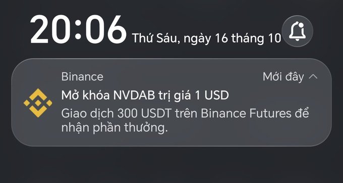 An iOS lock screen notification in Vietnamese from Binance at 20:06 on Friday, October 16, announcing a 1 USD NVDAB token airdrop for trading 300 USDT on Binance Futures.