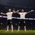 Two soccer players stand on the field with their arms outstretched, frozen mid-celebration after scoring. Their triumphant poses match the energy of the caption, where the poster is thrilled after winning their bet on Bellingham finding the net.