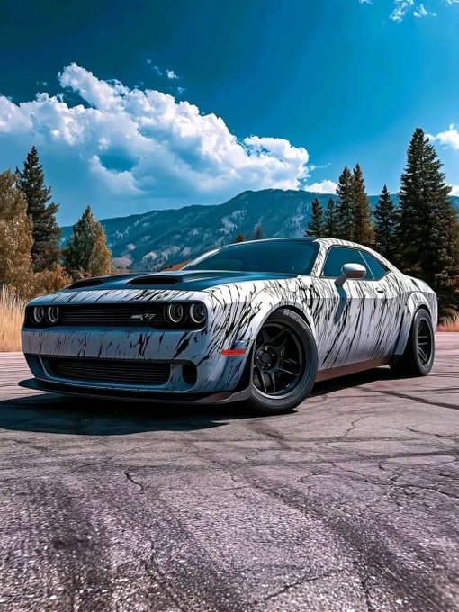 iced car with black rims and white body, parked on a dirt road surrounded by trees and mountains under a clear blue sky.