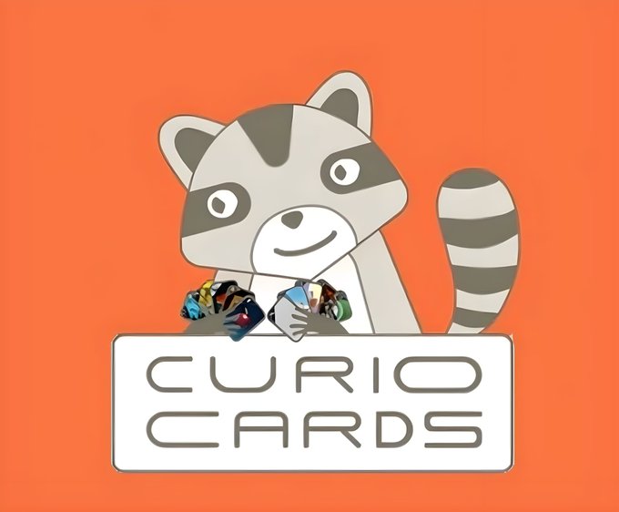 An orange background features a cartoon raccoon mascot holding colorful gem-like cards above a white sign that reads 'CURIO CARDS'.