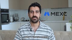 A man with a beard wearing a striped shirt being interviewed, with the MEXC exchange logo displayed in the top right corner and a text label below him.
